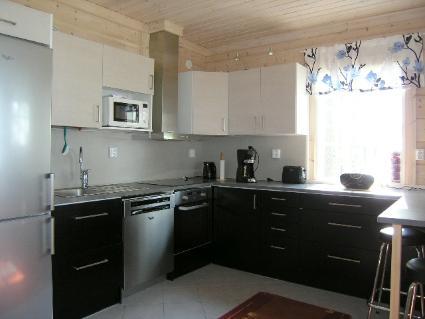 Interior view showcasing the high-ceiling living room and kitchen area of the Karikko holiday home.