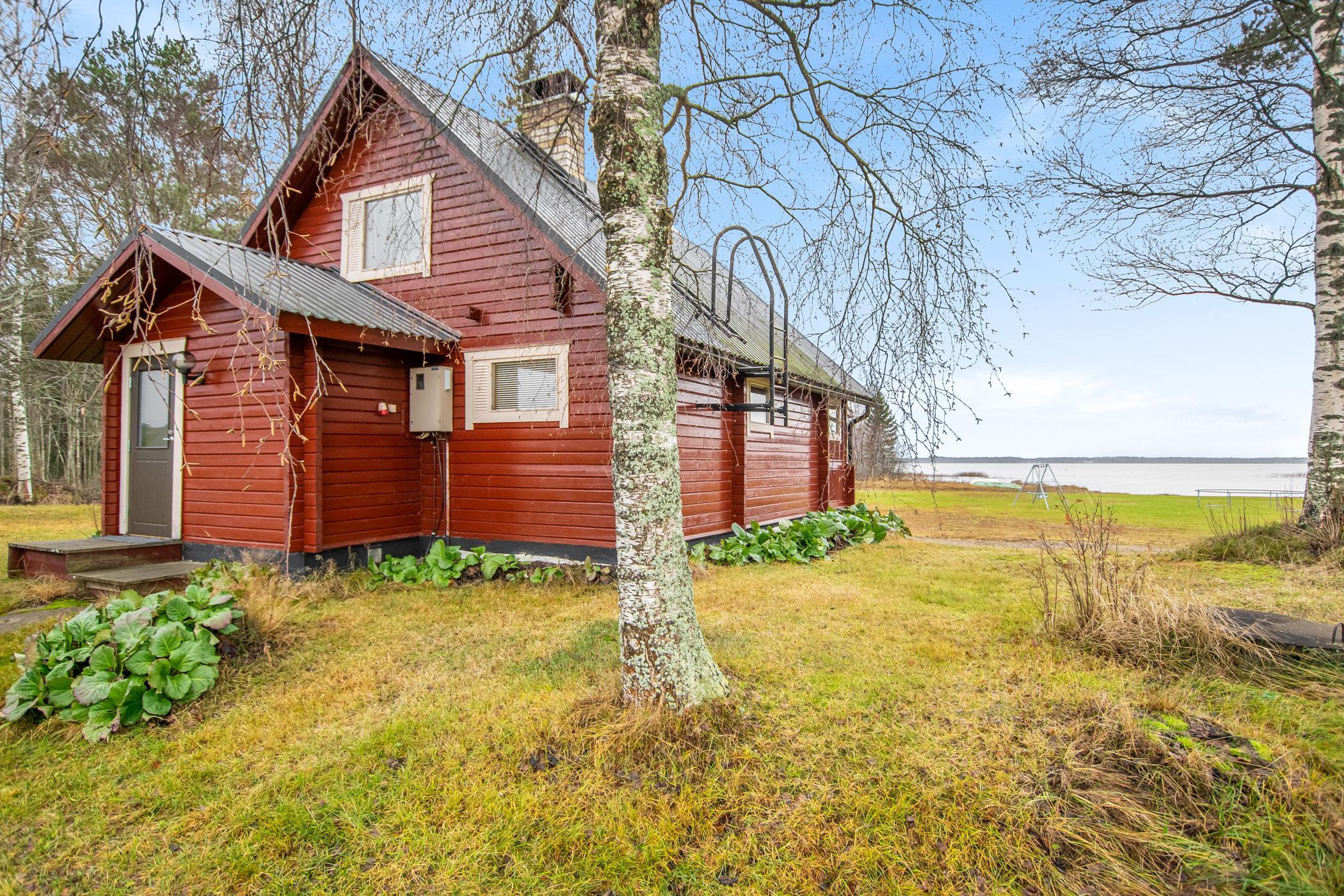 Exterior view of Kaunotar, showcasing its proximity to the serene Lake Halsuanjärvi and surrounding lush landscape.