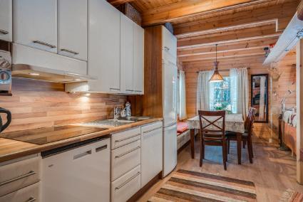 Cozy living area inside Ahonranta with wood furnishings and a view of the lake.