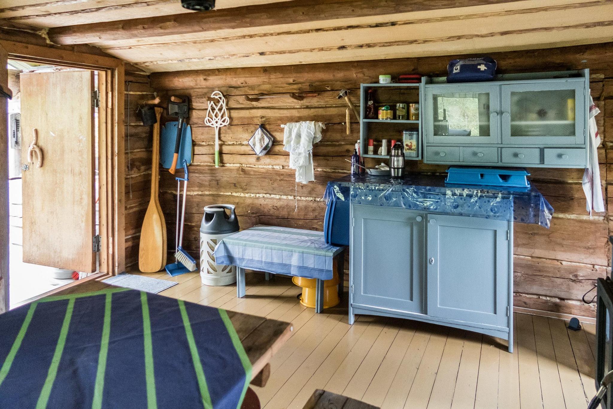 Rustic exterior of Kullaus wilderness cabin surrounded by dense forest.