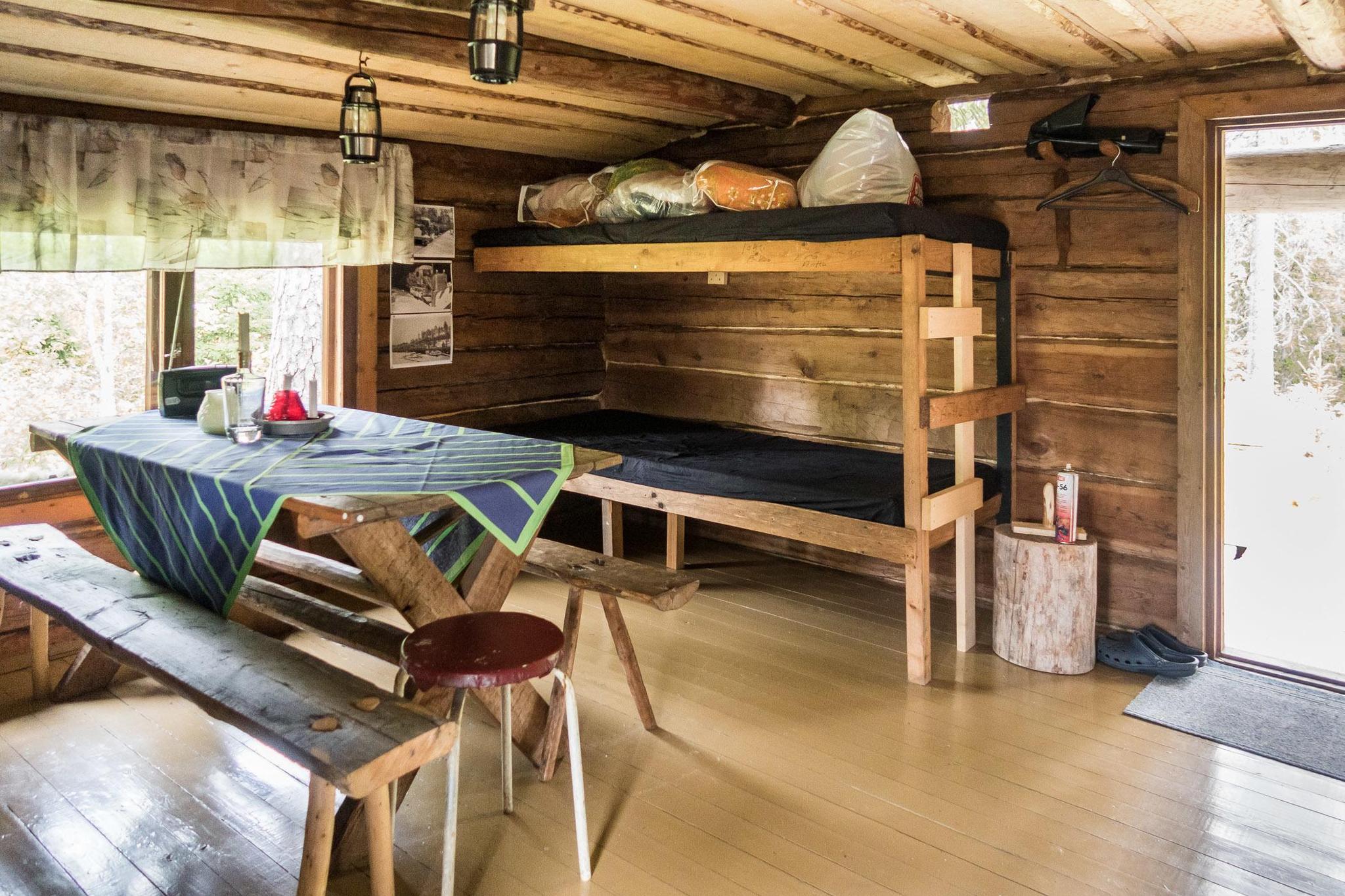 Interior view of Kullaus cabin showing bunk beds and wood stove.