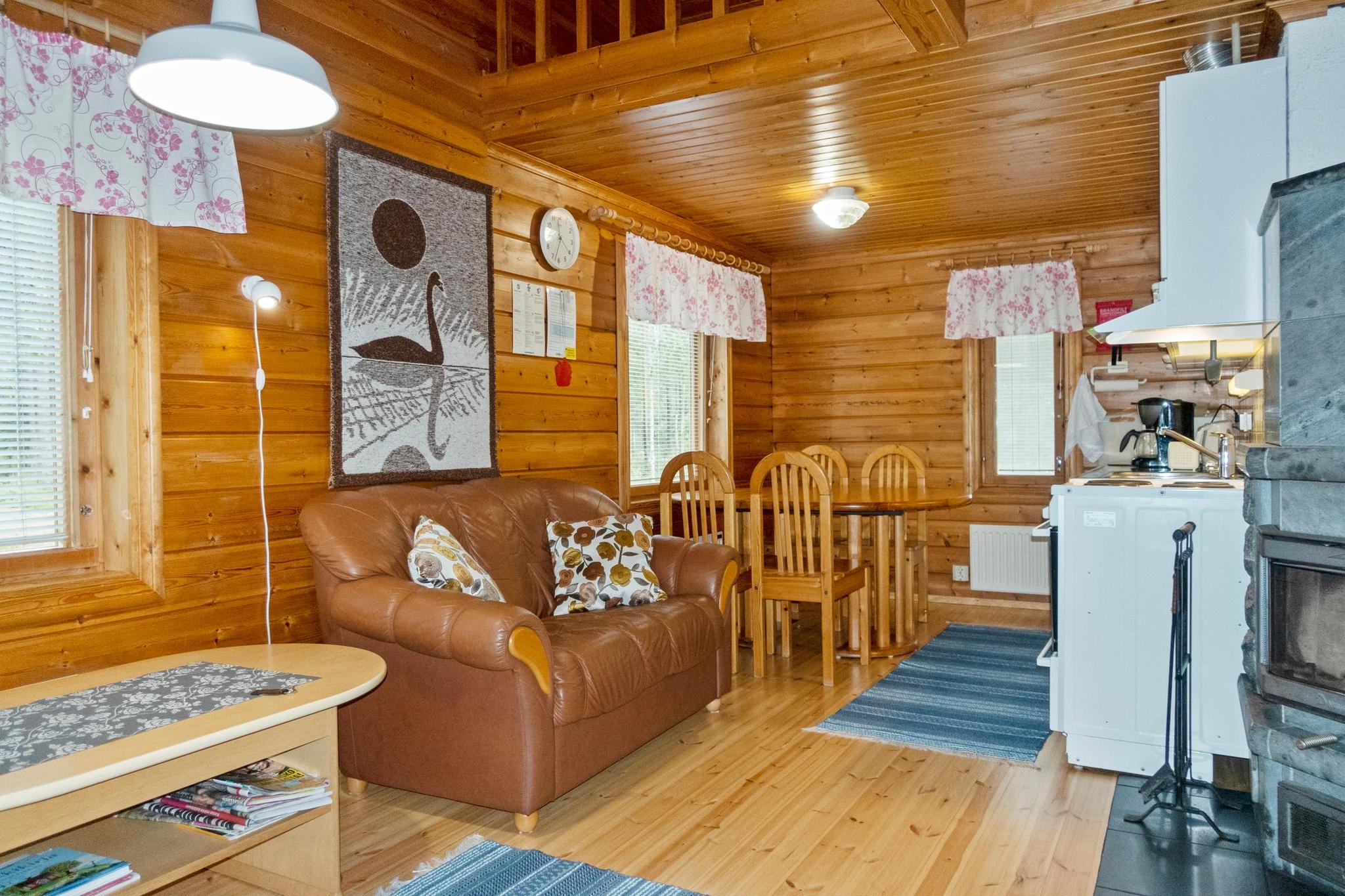 Cozy living area inside Lepokunnas with a fireplace and lake view.