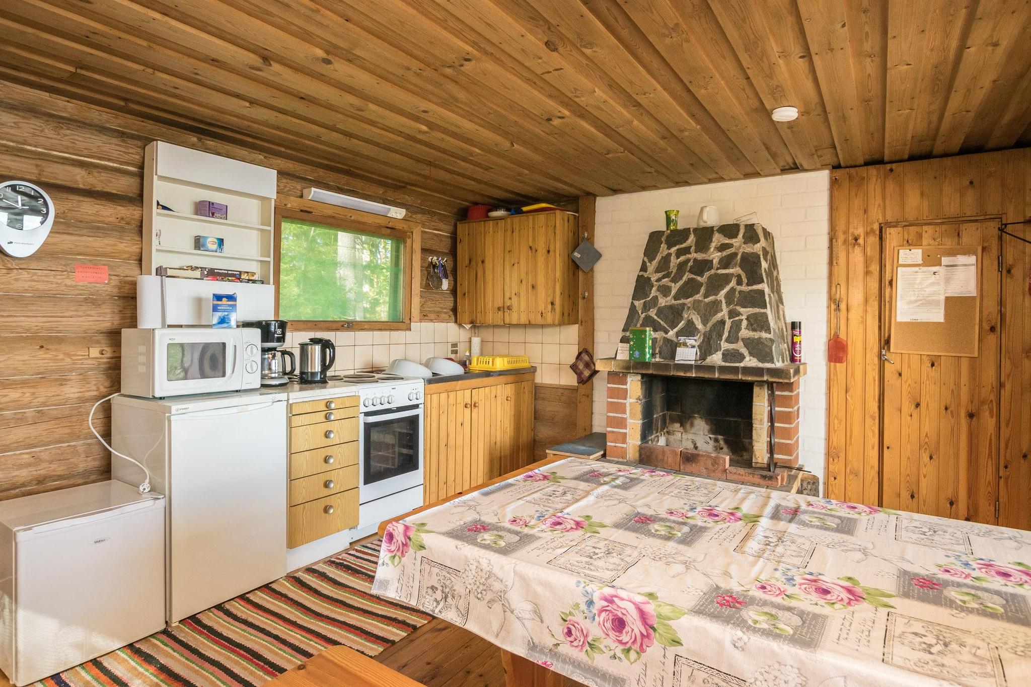 Inviting living area inside Piilopirtti with rustic decor and a warm fireplace.